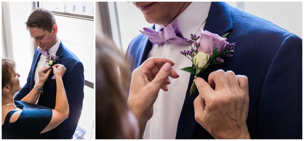 Mother of Bride helping groom to attach his purple rose boutonniere onto navy suit on wedding day in Milwaukee 