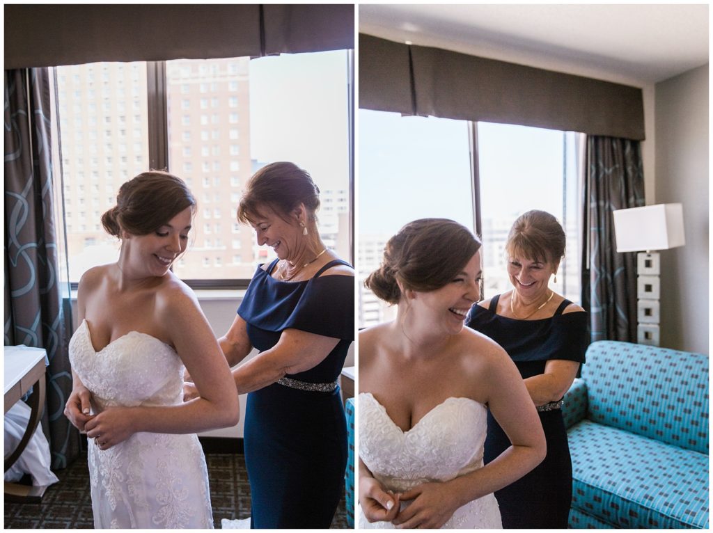 Mother of the bride helping the bride into wedding dress on her wedding day in Milwaukee