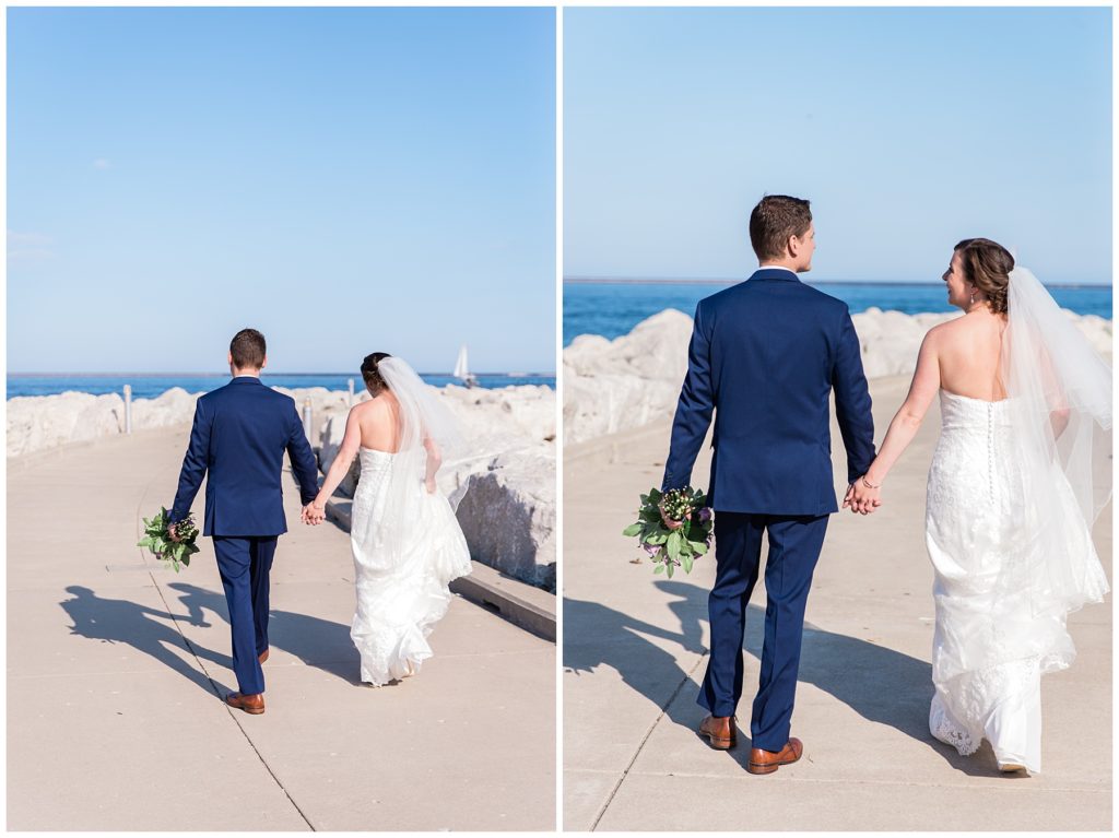 Bride and groom walking while holding hands on a Lake Michigan pier in Milwaukee