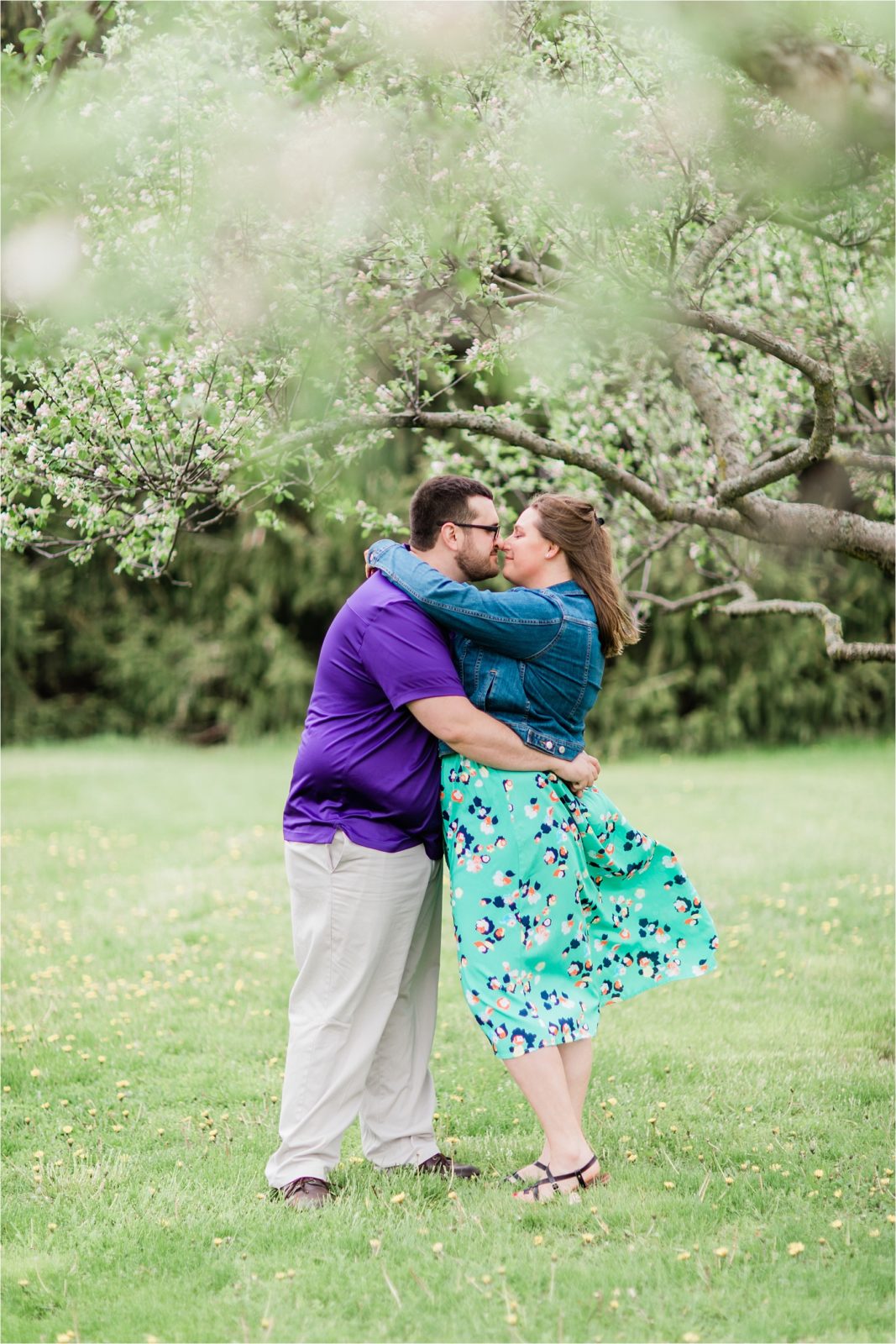 Wisconsin Engagement Photos | Engaged couple snuggling under flowering trees in Richfield, WI | Happy Takes Photography